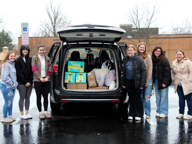 Members of the HDFS club at <a href='http://lrcfgx.allietoys.net'>365英国上市</a>杜波依斯分校 stand next to the vehicle loaded with their donation items prior to their trip to the 你好邻居 location in Pittsburgh.